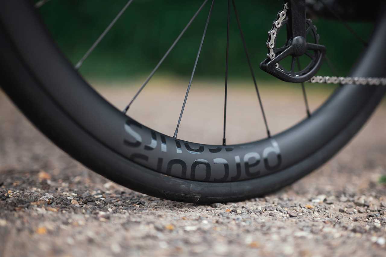closeup detail of parcours paniagua budget carbon aero road bike wheels on a bike